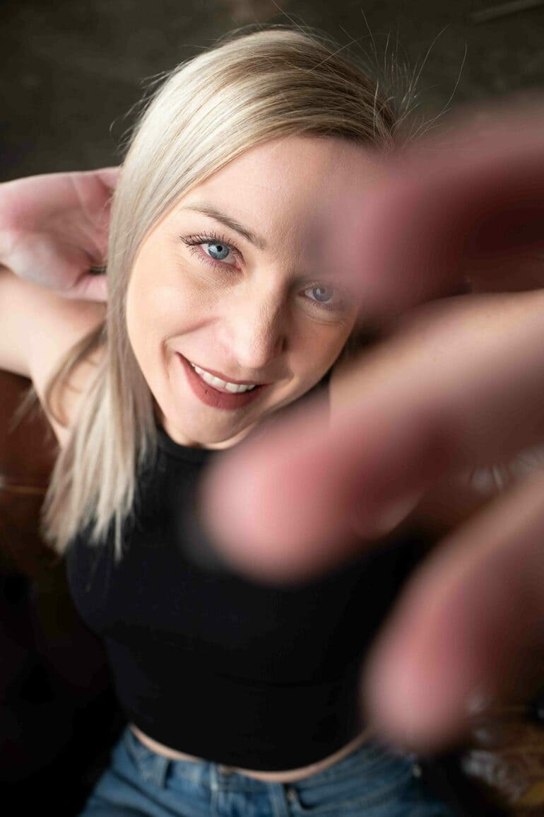 Aline sitzt im British Chair und lacht nach oben mit Hand-Störer